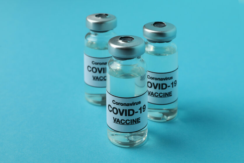 Vials of Covid - 19 vaccine on blue background